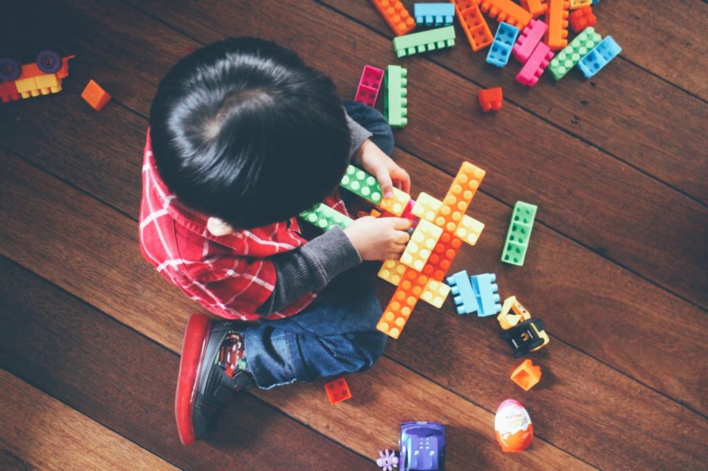 Kid playing with toys on the floor