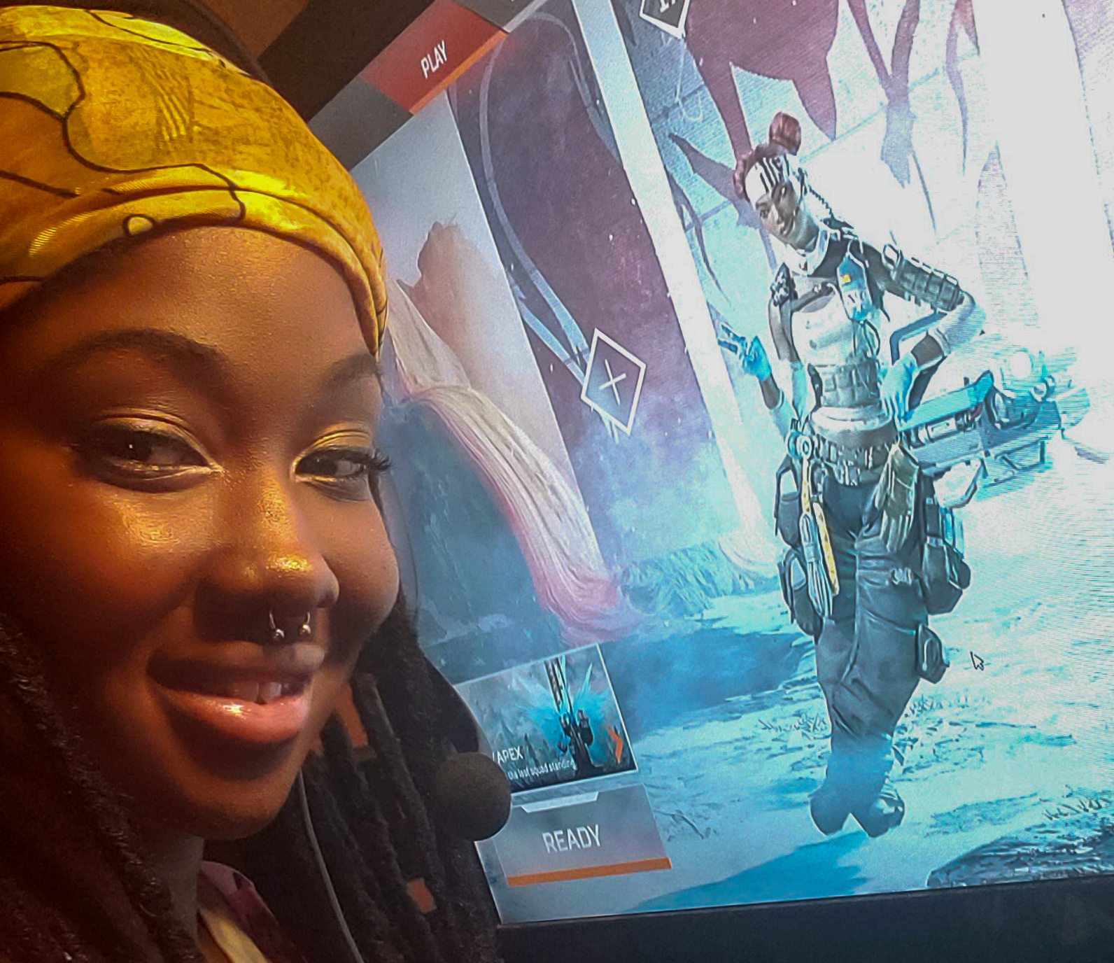 Symone in front of her Game PC with Apex Legends in the background on a computer screen