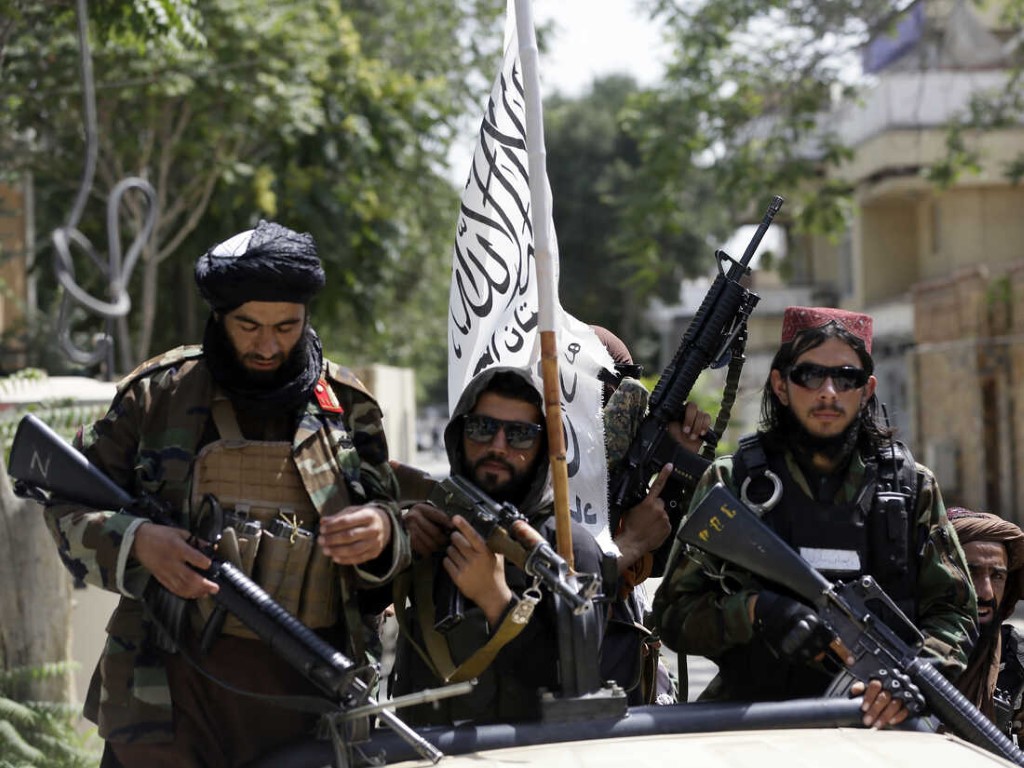 Taliban fighters display their flag on patrol in Kabul, Afghanistan,