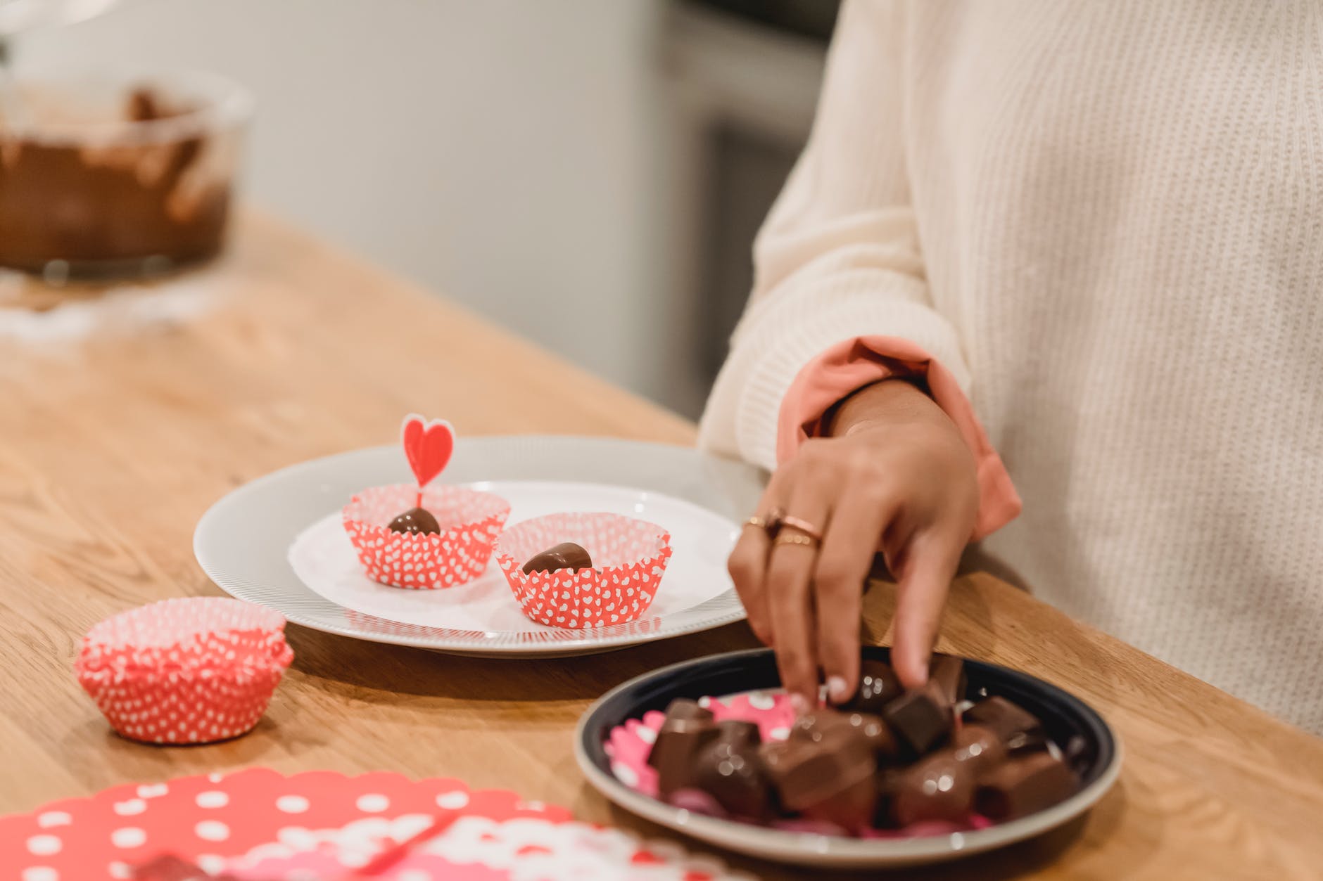 black woman taking chocolate sweets from plate near festive dessert